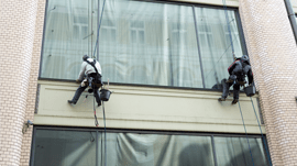Sun Services window cleaning technicians working on multi-story building windows