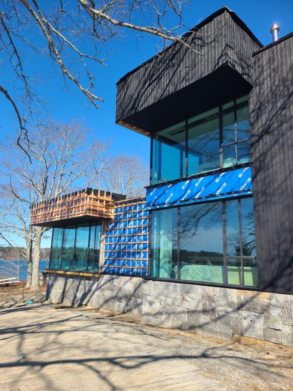 Modern coastal Maine home with extensive glass serviced by Sun Services, Inc.